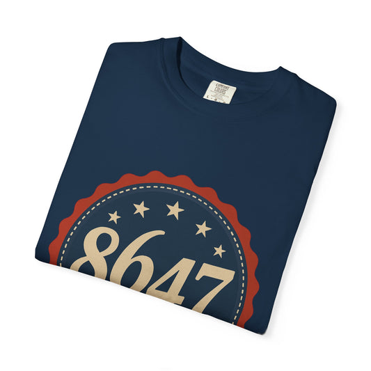 8647 DJT He's Gotta Go Unisex Garment-Dyed Tee. Large front logo design